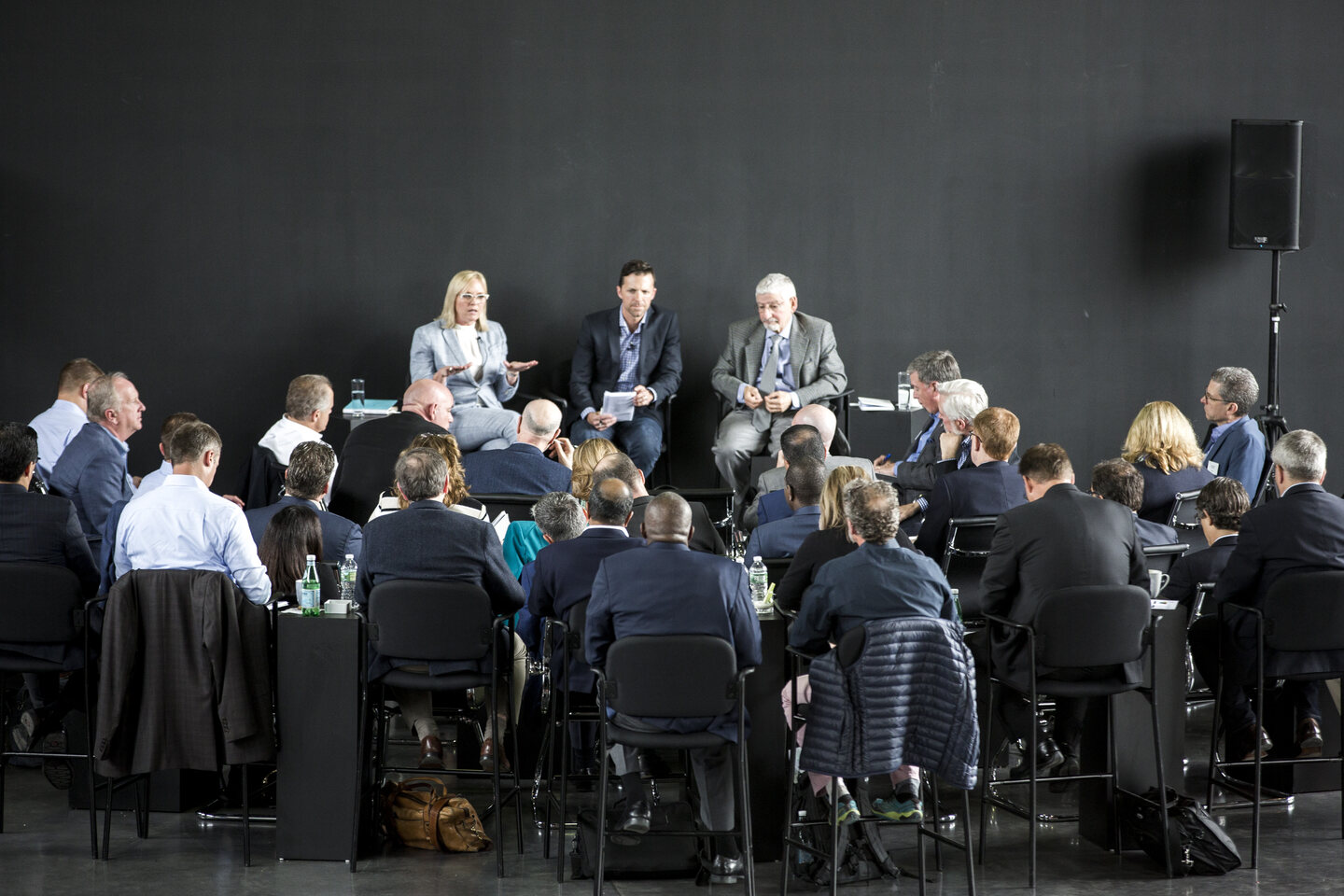 Mike Mudrey moderating a panel before a full room of executives